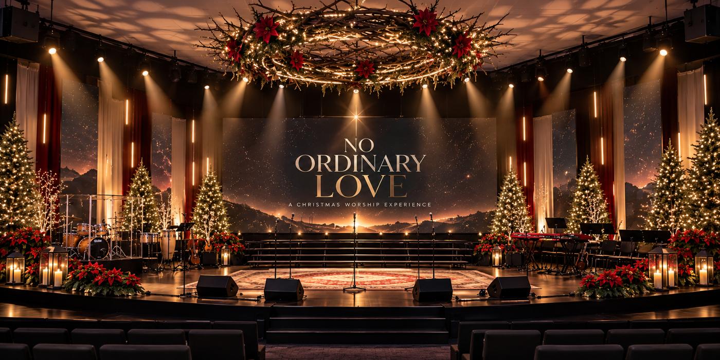 Concept render: Christmas worship stage with a grapevine wreath overhead, warm beams in haze, a starfield LED wall reading No Ordinary Love, LED pillars between red and ivory drapes, lit trees, poinsettias and lanterns.